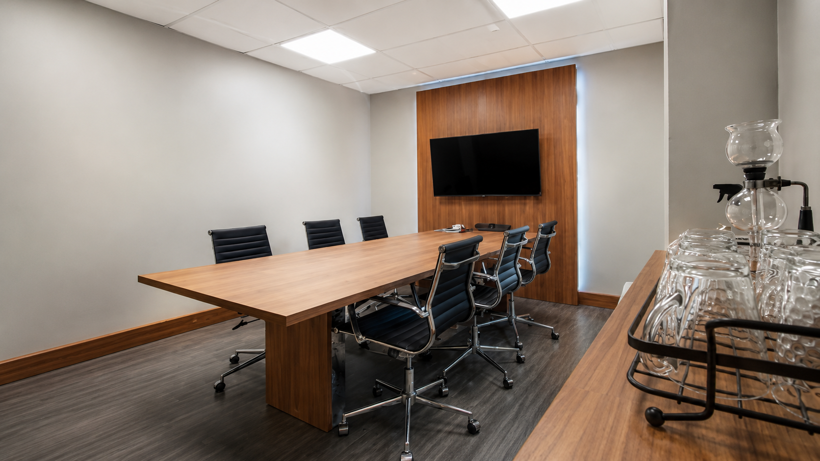 Sala corporativa com painel amadeirado: projeto de móveis planejados da ArtPro em Porto Alegre.